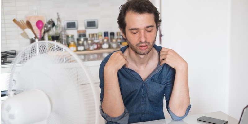 Man cooling off in front of fan